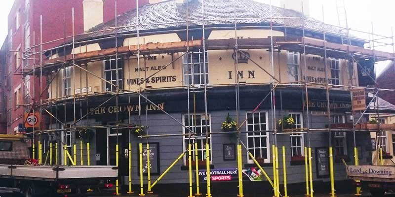 distance front view of a round shaped sheffield pub with scaffolding by brooks