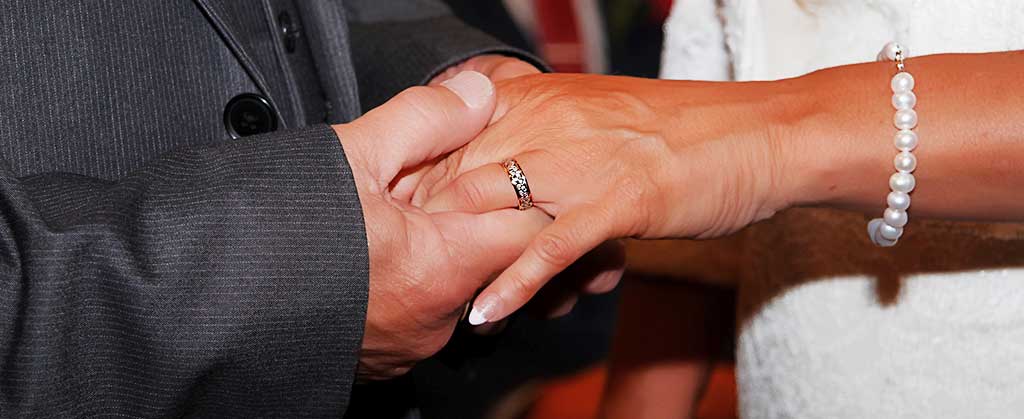 close up photograph of a wedding couples hands complete with exchanged rings