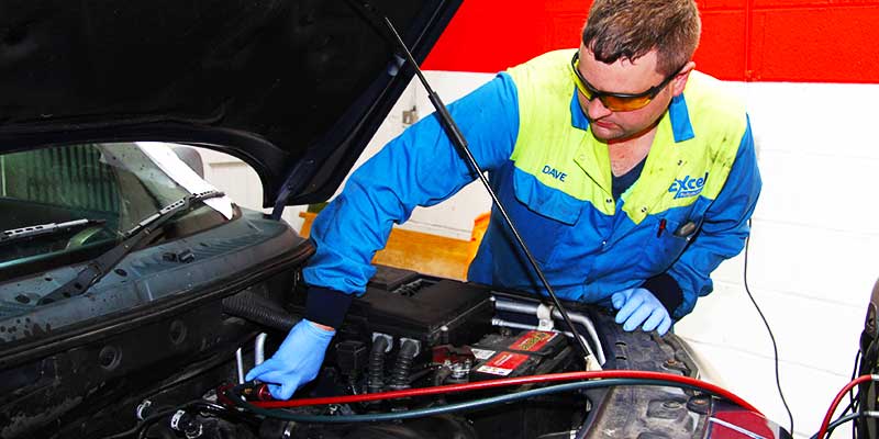 distance corner view of excel mechanic regassing a cars air conditioning system