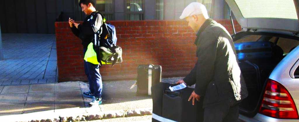 close up rear corner view of an atlantic airport taxis driver loading a customers luggage