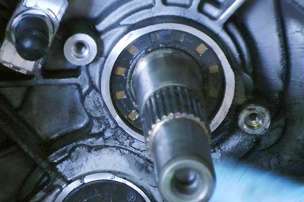 Broken Main Gearbox Seal close up view inside a ford gearbox bell housing showing the main shaft with oil leaking from its seal