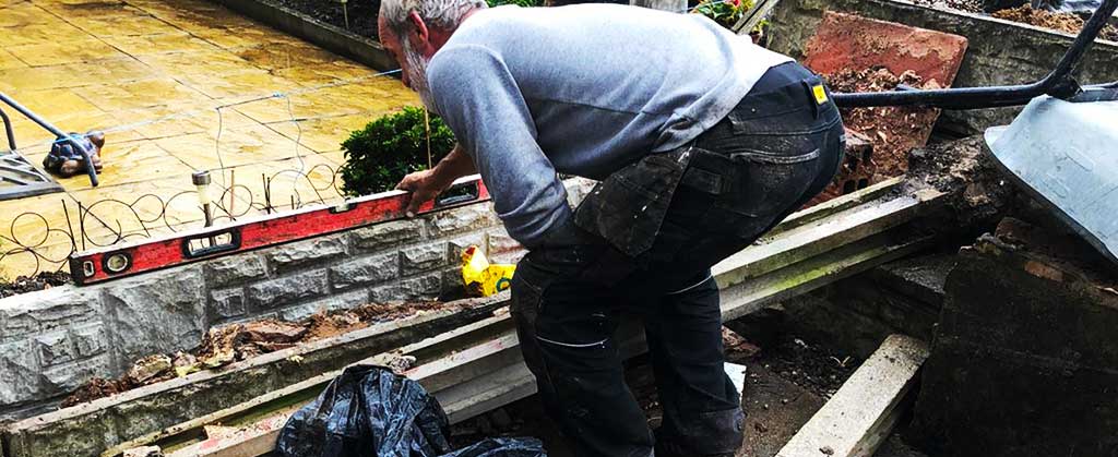 close up of a small wall being checked for level by property maintenances fecne installations expert