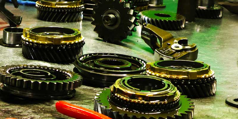 close up of gearbox gears spread across a bench at m and t workshop awaiting fitting in an audi greabox rebuild