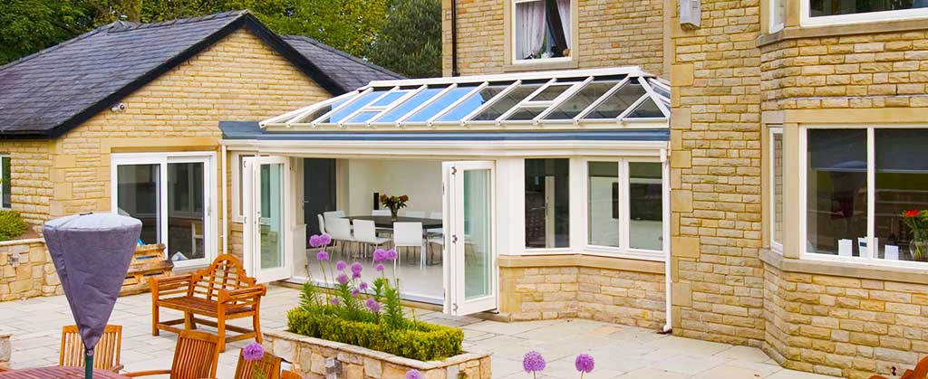 distance view of a smart conservatory design which is fitted in between 3 buildings allowing thm all to connect under roof