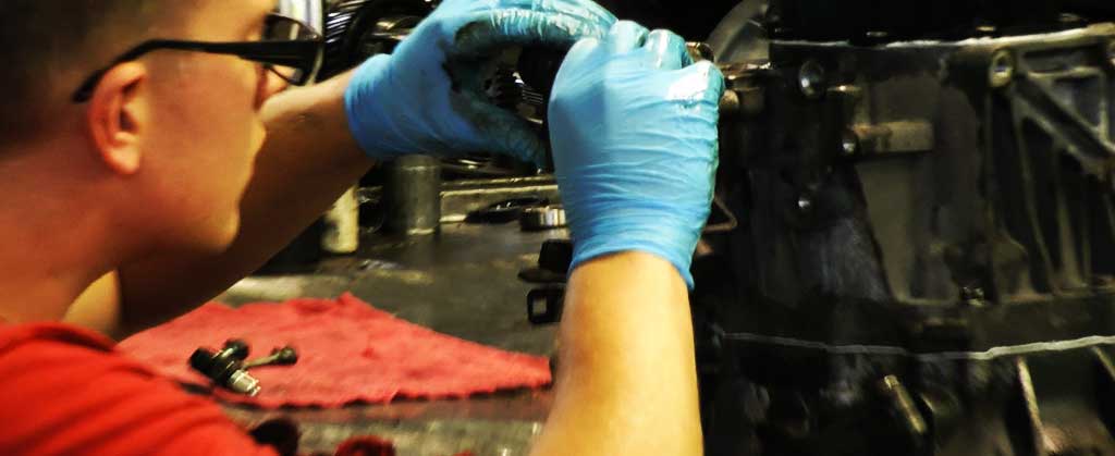 close up view of an m and t transmissions gearbox expert fixing a ford gearbox