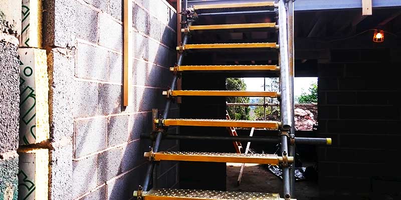 close up of a tempory staircase constructed entirely from just scaffold connected two floors on this building project