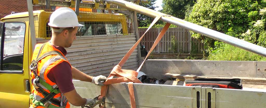 close up side view of a brooks scaffolder loading scaffolding onto their gold coloured truck