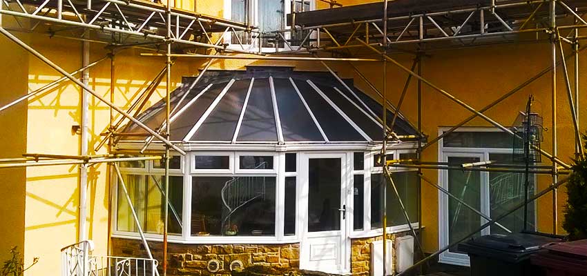 Scaffolding attractive home surrounded by safe secure scaffolding for work on its roof