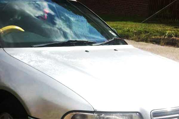 photo of an old scrap silver audi a4 from 1996 highlighting all the flaked laquer and paint on the bonnet